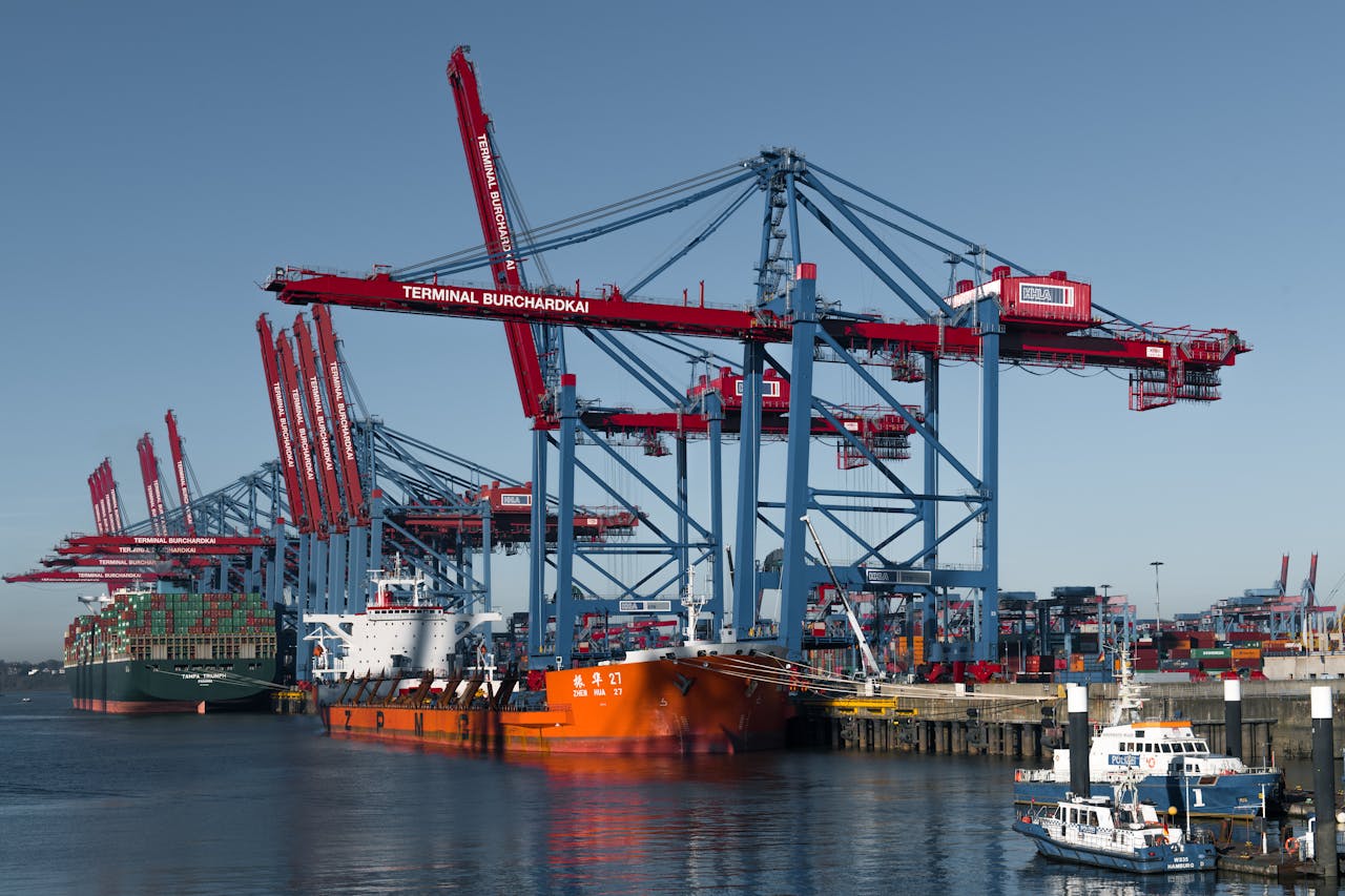 Container ships docked at Hamburg's busy Terminal Burchardkai under cranes.