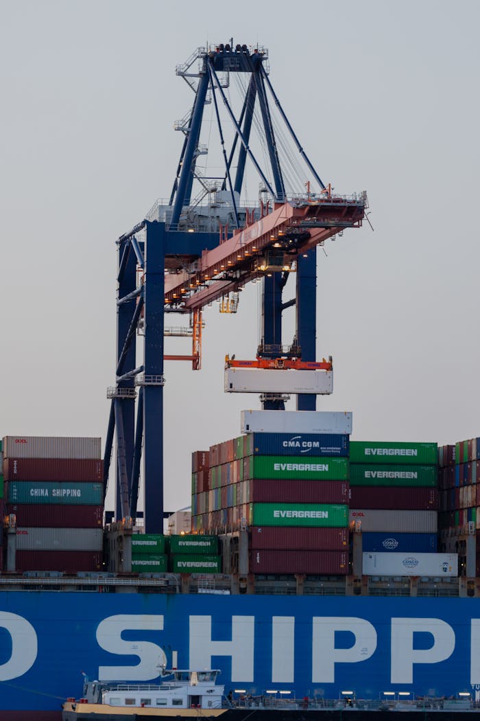 A large cargo container terminal with cranes at the Port of Rotterdam during twilight.